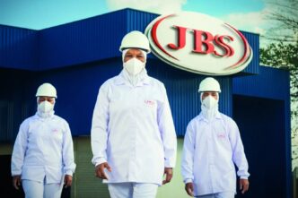 Fábrica da JBS com funcionários na frente